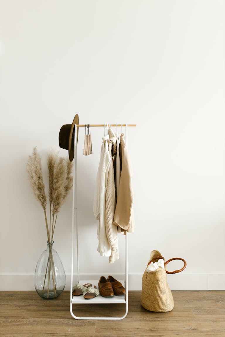 A chic minimalist clothing rack with neutral garments in a bright, modern setting.