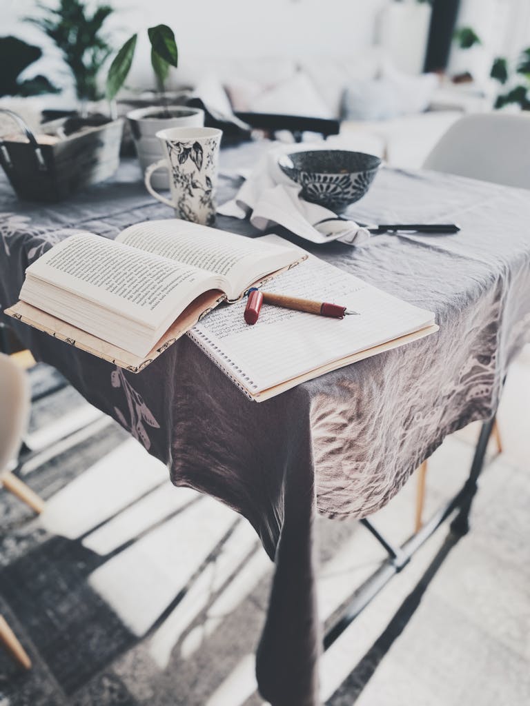 A sunlight-lit table in Avcılar with books, plants, and a notebook, creating a relaxing atmosphere.