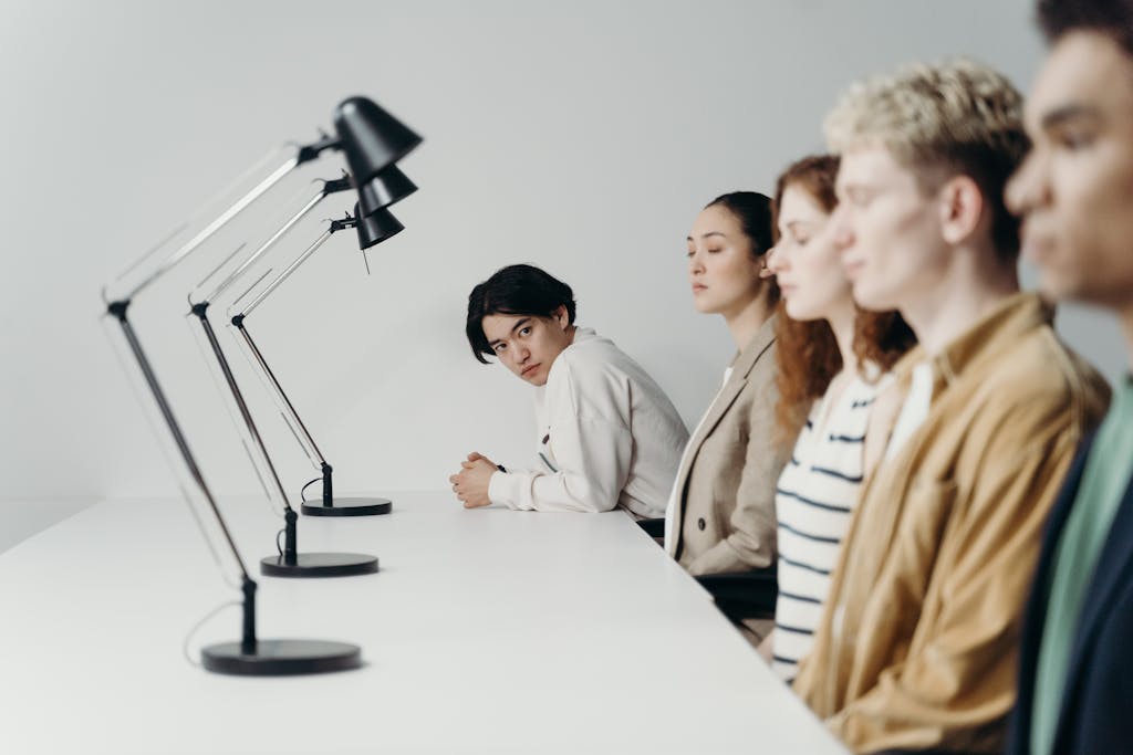 Group of professionals engaged in a focused office meeting setting under modern lamps.